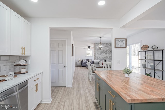 kitchen with white cabinetry, butcher block countertops, stainless steel dishwasher, and hanging light fixtures