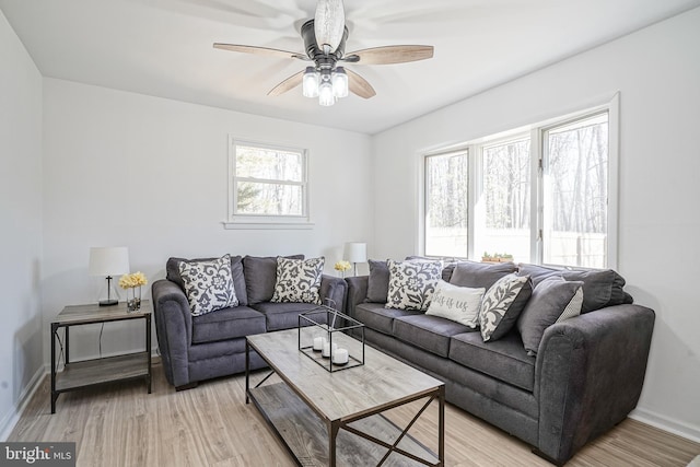 living room featuring ceiling fan, a wealth of natural light, and light hardwood / wood-style floors