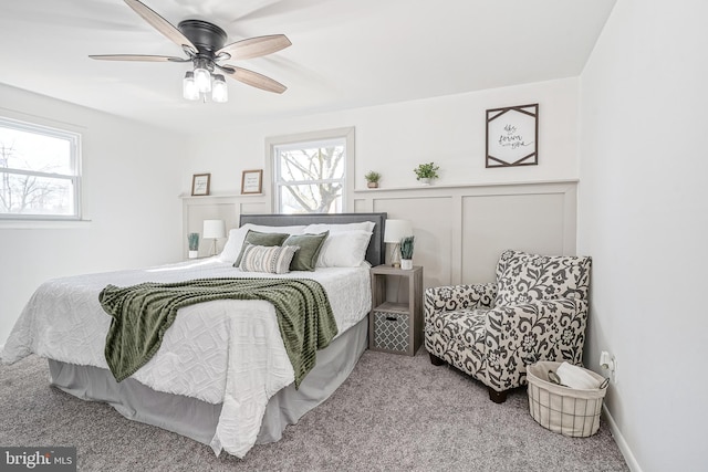 carpeted bedroom featuring multiple windows and ceiling fan