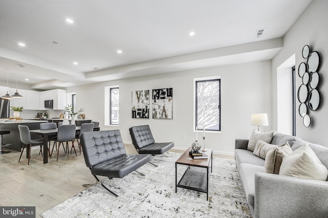 living room featuring light wood finished floors, baseboards, visible vents, and recessed lighting