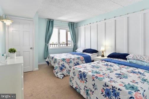 bedroom featuring light carpet and a textured ceiling