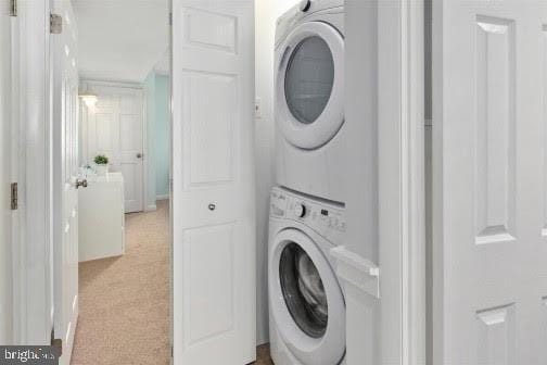 clothes washing area with stacked washer / dryer