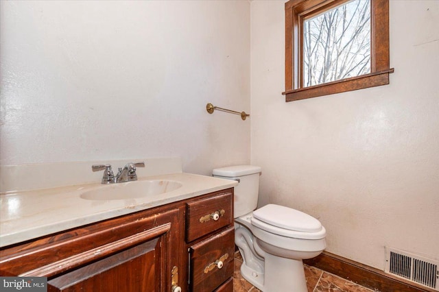 bathroom with visible vents, toilet, and vanity