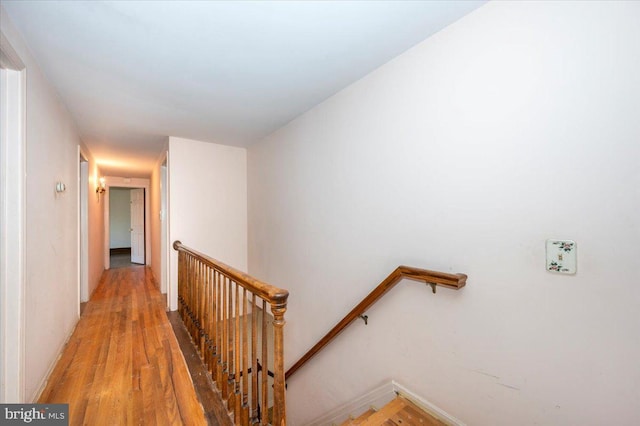 hall featuring an upstairs landing and light wood finished floors