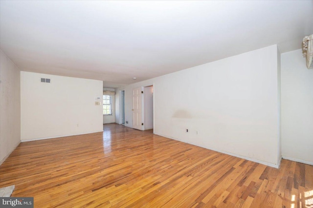 unfurnished room with light wood-style flooring and visible vents