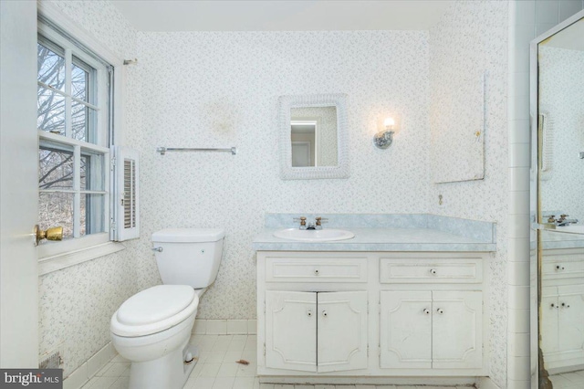 full bath with tile patterned floors, toilet, vanity, and wallpapered walls