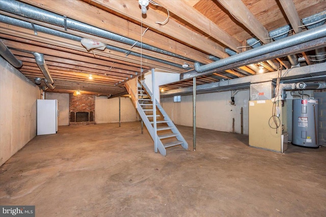 unfinished below grade area with water heater, heating unit, stairs, and freestanding refrigerator