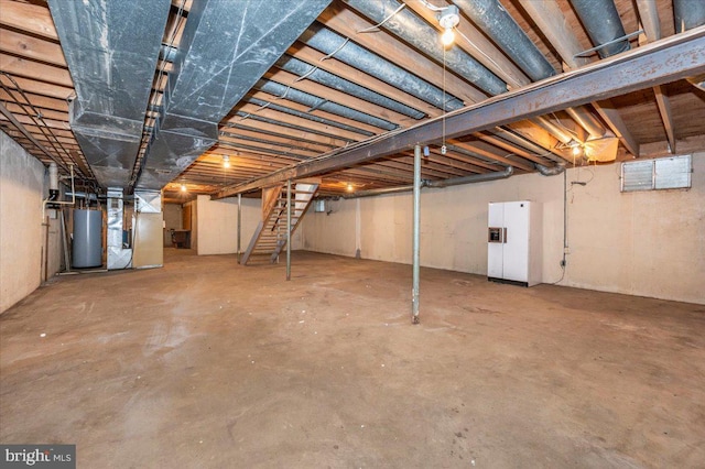 unfinished basement featuring gas water heater, heating unit, and white refrigerator with ice dispenser