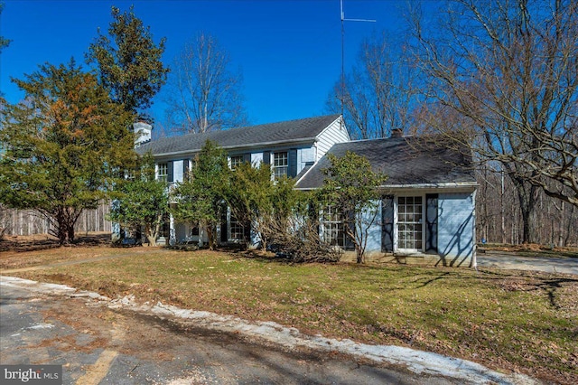 view of front of home with a chimney and a front yard