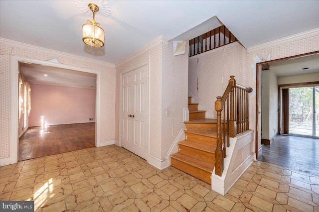 staircase featuring wallpapered walls, crown molding, baseboards, and wood finished floors