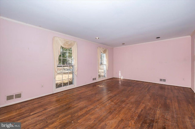 spare room with visible vents, crown molding, and wood finished floors