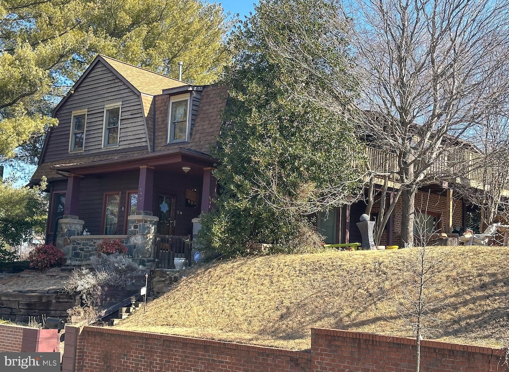 view of front of property featuring a shingled roof and a gambrel roof