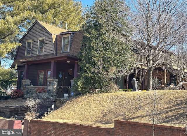 view of front of property featuring a shingled roof and a gambrel roof