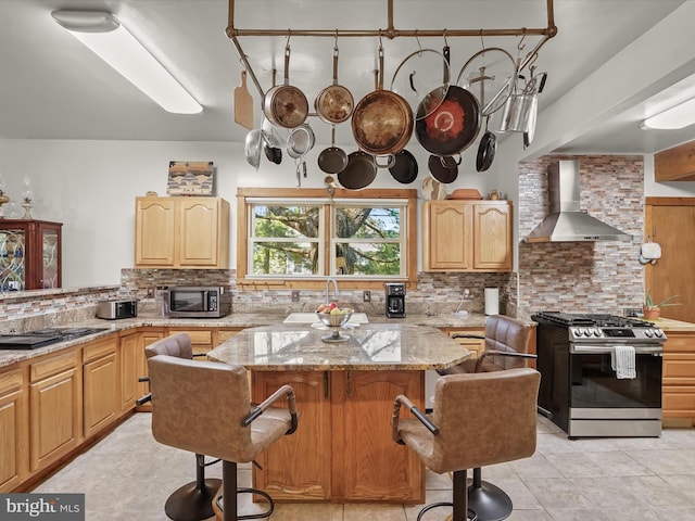 3137 18th St NE, Washington, DC 20018 - kitchen with a kitchen breakfast bar, decorative backsplash, wall chimney range hood, light stone countertops, and appliances with stainless steel finishes