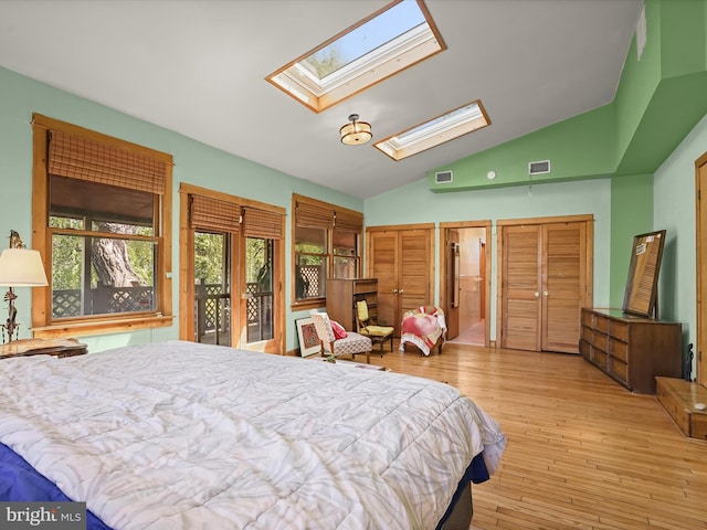 3137 18th St NE, Washington, DC 20018 - bedroom featuring wood-type flooring, lofted ceiling with skylight, visible vents, and two closets