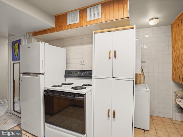 3137 18th St NE, Washington, DC 20018 - kitchen featuring tile walls, light tile patterned floors, washer / clothes dryer, range with electric stovetop, and white cabinets