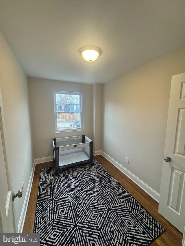 interior space with dark wood-type flooring and baseboards