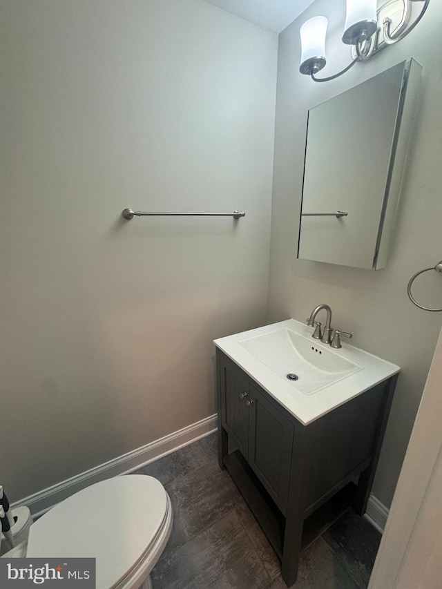 half bath featuring toilet, baseboards, wood finished floors, and vanity