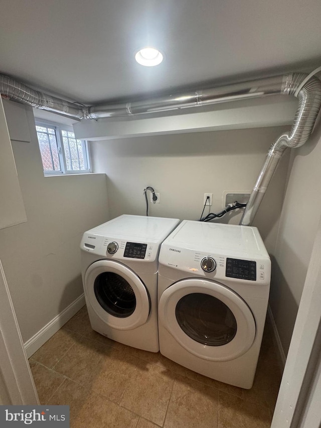 laundry area featuring tile patterned floors, washing machine and dryer, and baseboards