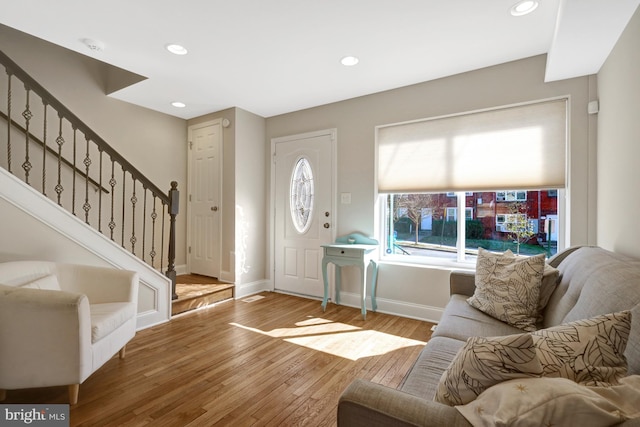 foyer with baseboards, stairway, wood finished floors, and recessed lighting