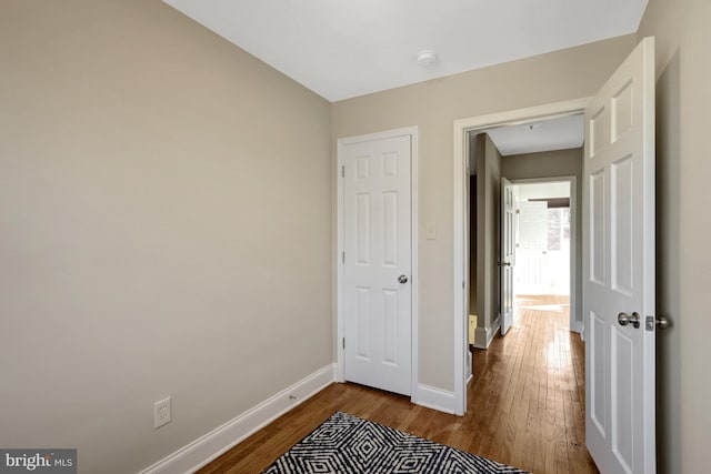 hallway with dark wood-style floors and baseboards