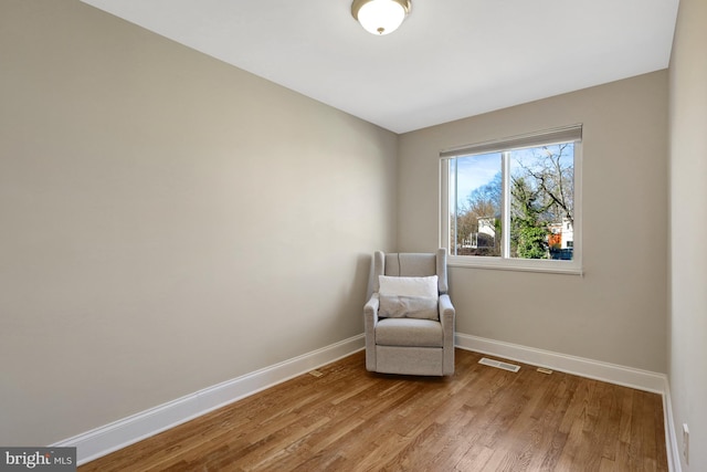 unfurnished room with light wood-style floors, visible vents, and baseboards