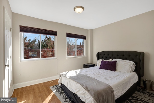 bedroom with light wood-style flooring and baseboards