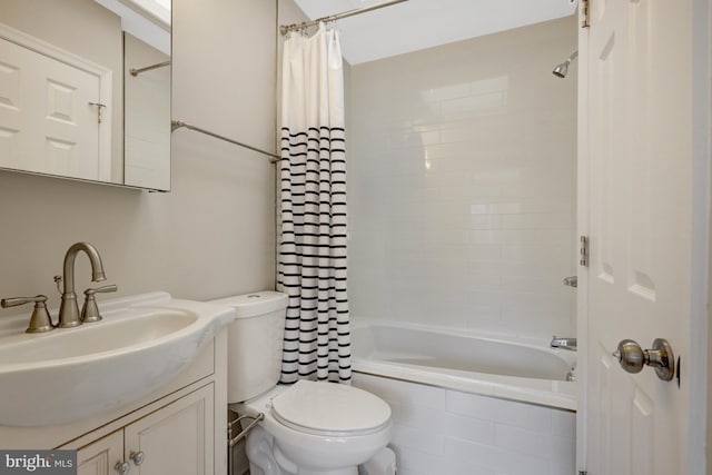 full bathroom featuring tiled shower / bath combo, vanity, and toilet