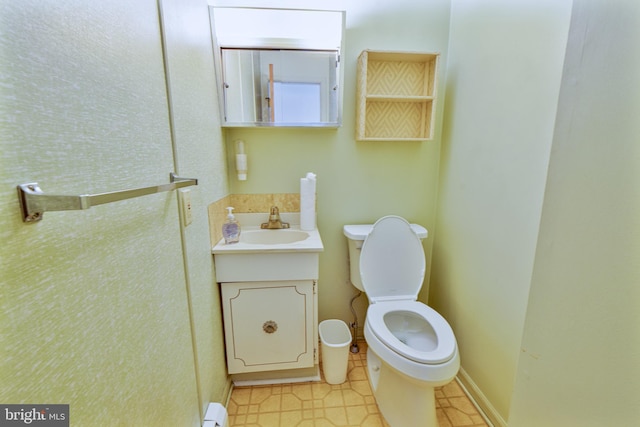 bathroom with vanity, toilet, and baseboard heating