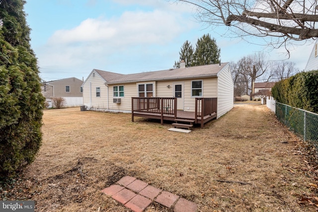 back of property featuring a wooden deck and a yard