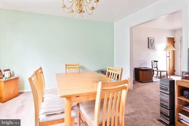 carpeted dining room with a notable chandelier