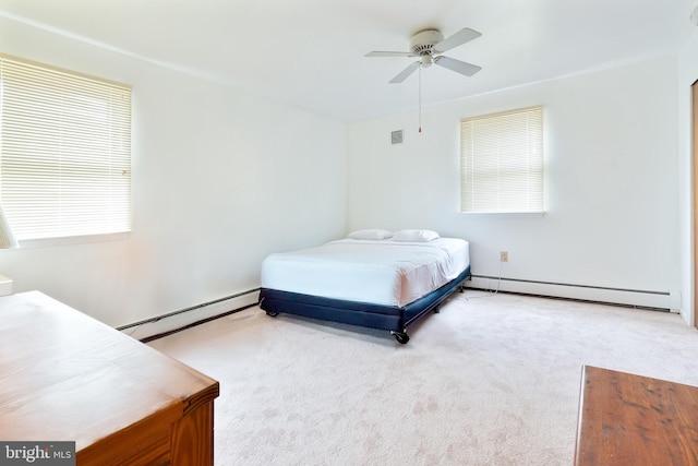 bedroom with baseboard heating, light colored carpet, and multiple windows