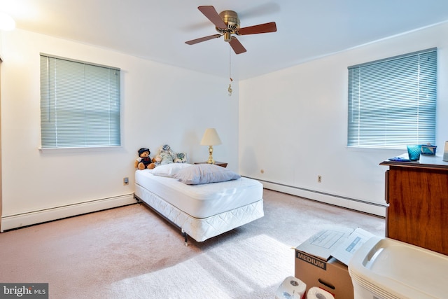 carpeted bedroom featuring a baseboard heating unit and ceiling fan