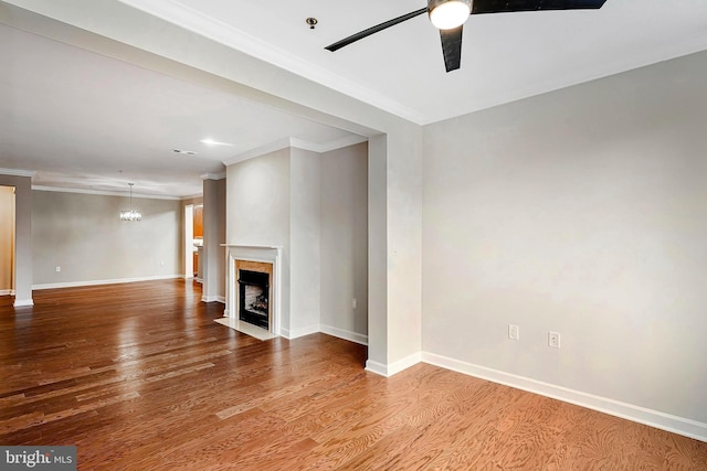 unfurnished living room featuring ceiling fan with notable chandelier, light wood-type flooring, and crown molding