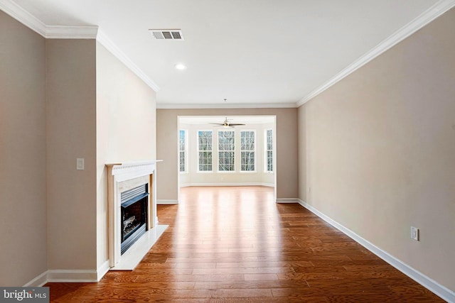 unfurnished living room featuring hardwood / wood-style floors, ceiling fan, ornamental molding, and a fireplace