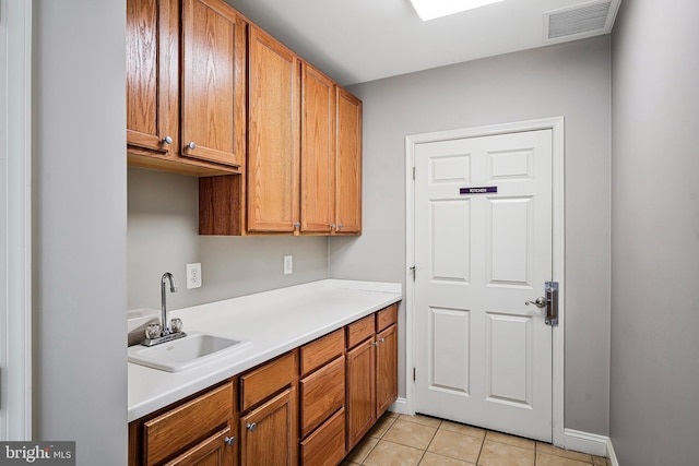 kitchen featuring light tile patterned floors and sink