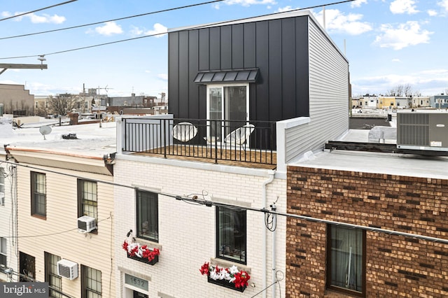 exterior space with a balcony and a wall mounted air conditioner