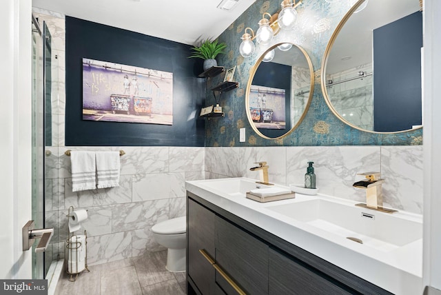 bathroom with vanity, tile walls, and toilet