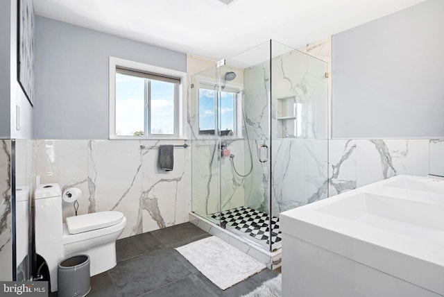 bathroom with walk in shower, tile walls, vanity, and toilet