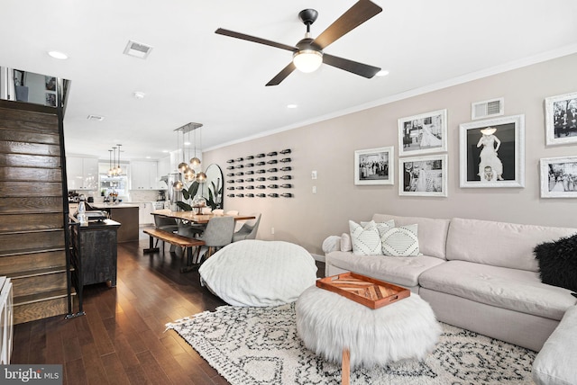 living room featuring dark hardwood / wood-style flooring, ornamental molding, and ceiling fan