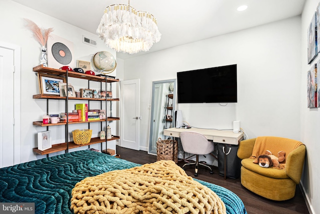 bedroom with dark wood-type flooring and a notable chandelier