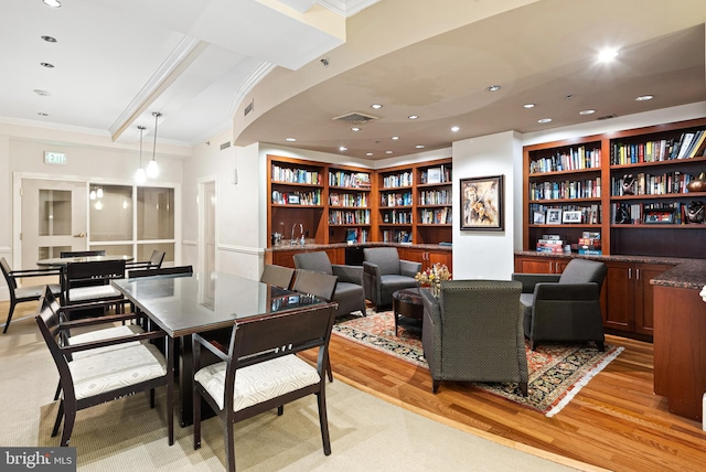 interior space with crown molding, built in shelves, and light wood-type flooring