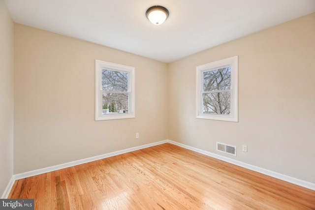 spare room with a healthy amount of sunlight and light hardwood / wood-style floors