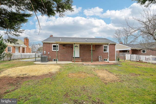 rear view of house with a yard, a patio, and central air condition unit