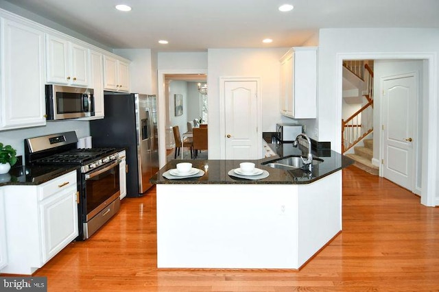 kitchen featuring light wood-type flooring, recessed lighting, stainless steel appliances, white cabinetry, and a sink