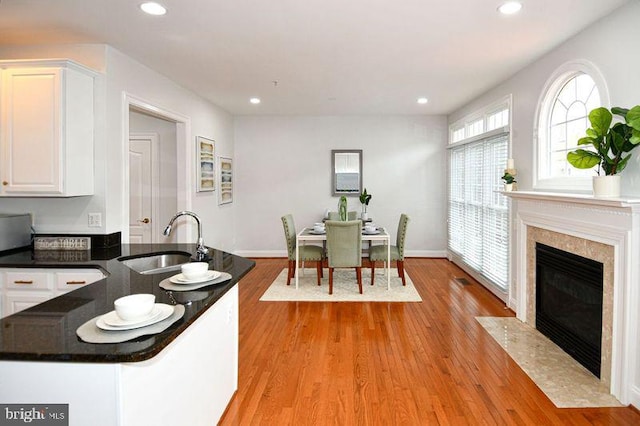 dining space with recessed lighting, light wood-style flooring, and a fireplace