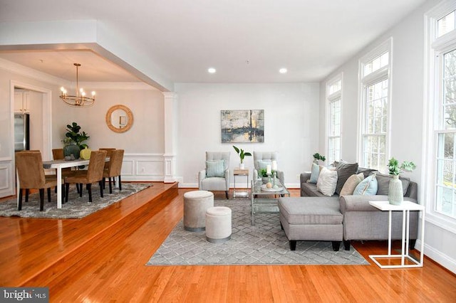 living area featuring a notable chandelier, recessed lighting, a decorative wall, and light wood-style floors