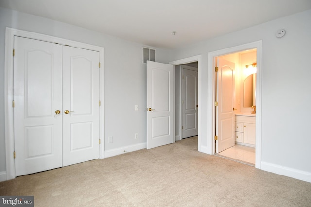 unfurnished bedroom featuring baseboards, visible vents, a closet, light carpet, and connected bathroom