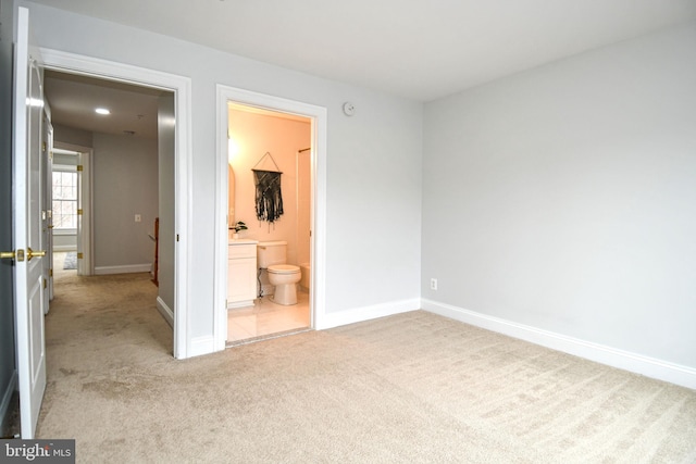 unfurnished bedroom featuring carpet flooring, baseboards, and connected bathroom