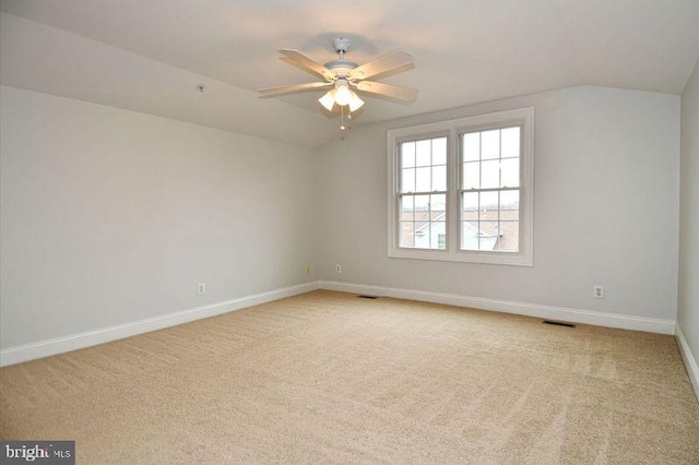 unfurnished room featuring vaulted ceiling, carpet, and visible vents